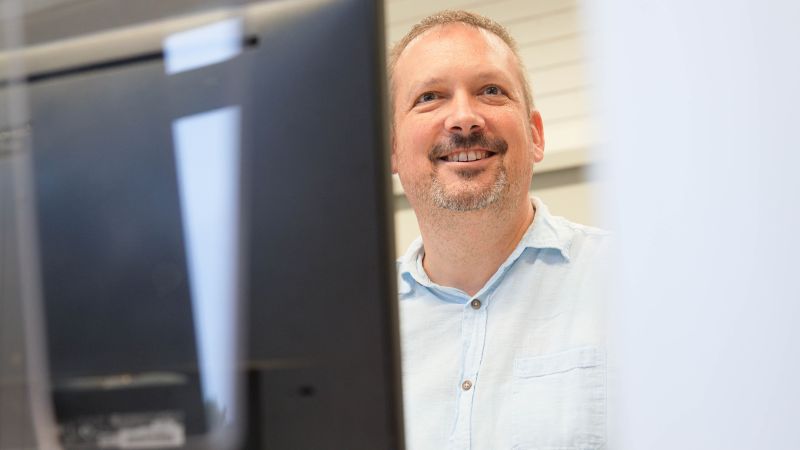 Erwachsener sitzt hinter PC-Bildschirm