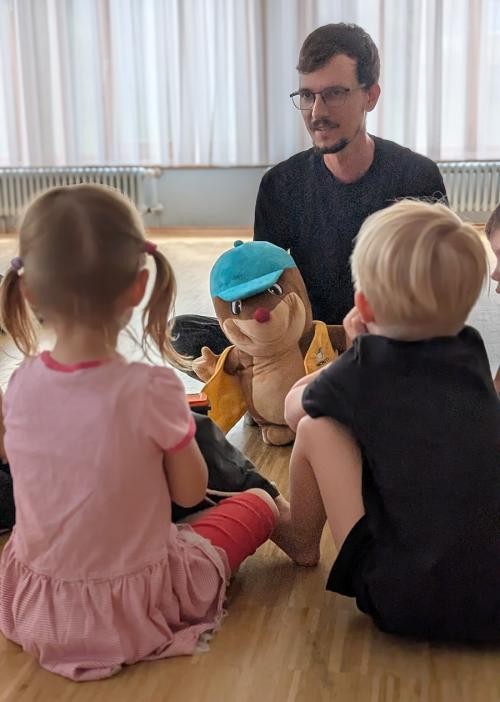 Sitzkreis mit Kindern und Monti dem Maulwurf