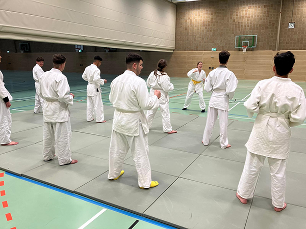 Schüler in Judoanzügen in einer Sporthalle beim Respekttraining