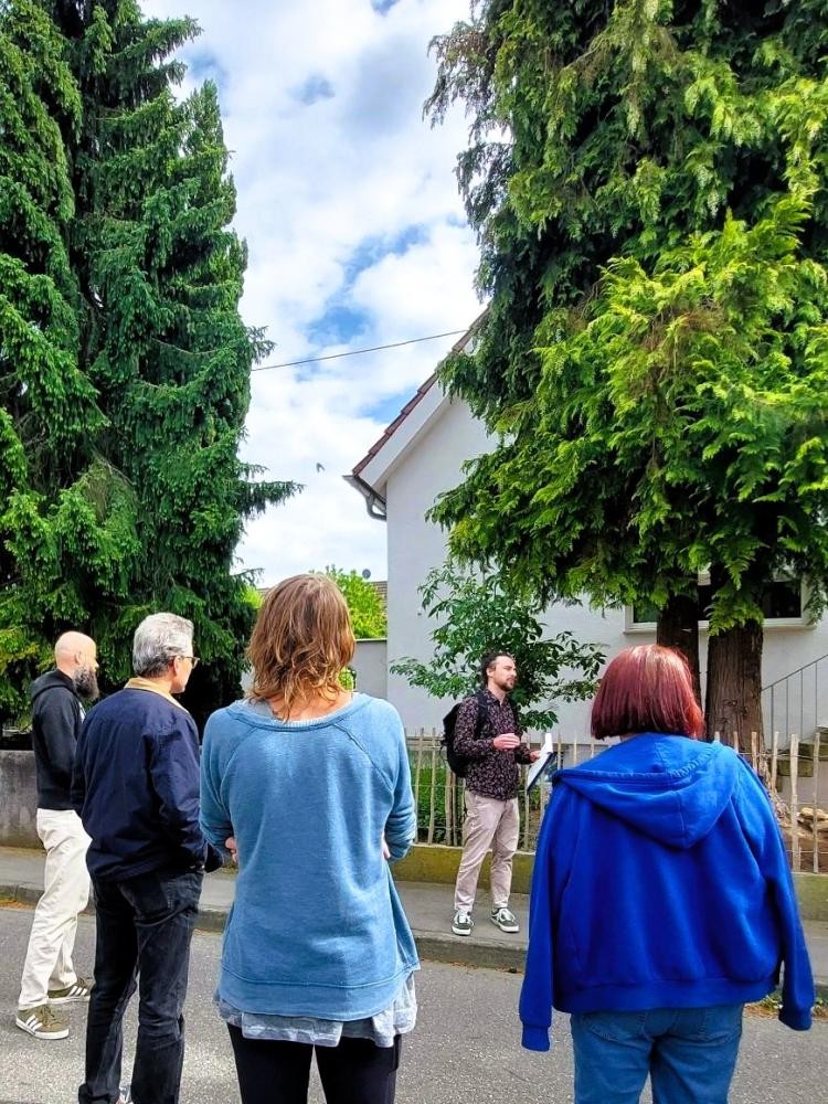 Personen auf der Straße vor einem Haus beim Energiespaziergang