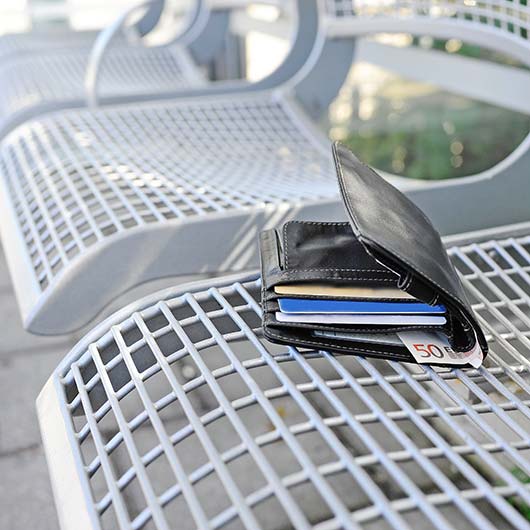 ein Geldbeutel liegt auf einer Parkbank