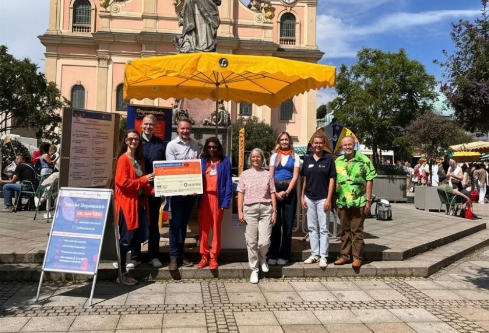 Teilnehmende der Aktion zum Tag der Organspende stehen gemeinsam vor dem Informationsstand auf dem Ludwigsburger Marktplatz. 