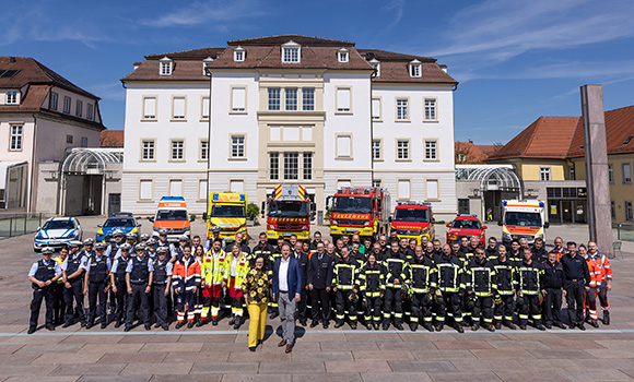Vor dem Ludwigsburger Rathaus stehen neun Fahrzeuge von Feuerwehr, Rettungsdiensten und Polizei. Davor stehen in einer Reihe cirka 70 Einsatzkräfte sowie Oberbürgermeister Dr. Matthias Knecht und Erste Bürgermeisterin Renate Schmetz.
