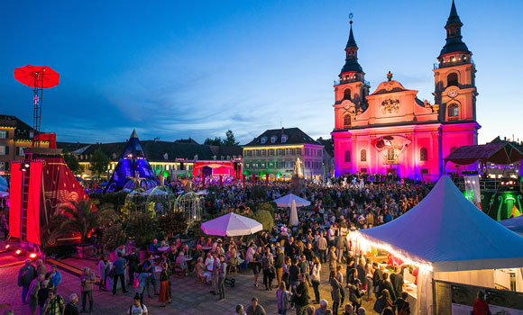 stimmungsvoll beleuchteter Markplatz voller Menschen bei der Venezianischen  Messesse