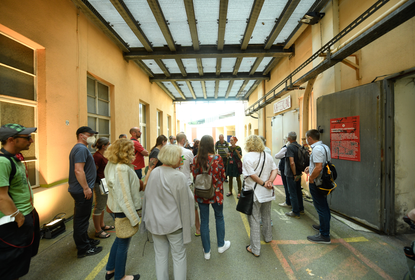 Eine Menschengruppe wird von einer Frau über das Areal geführt.