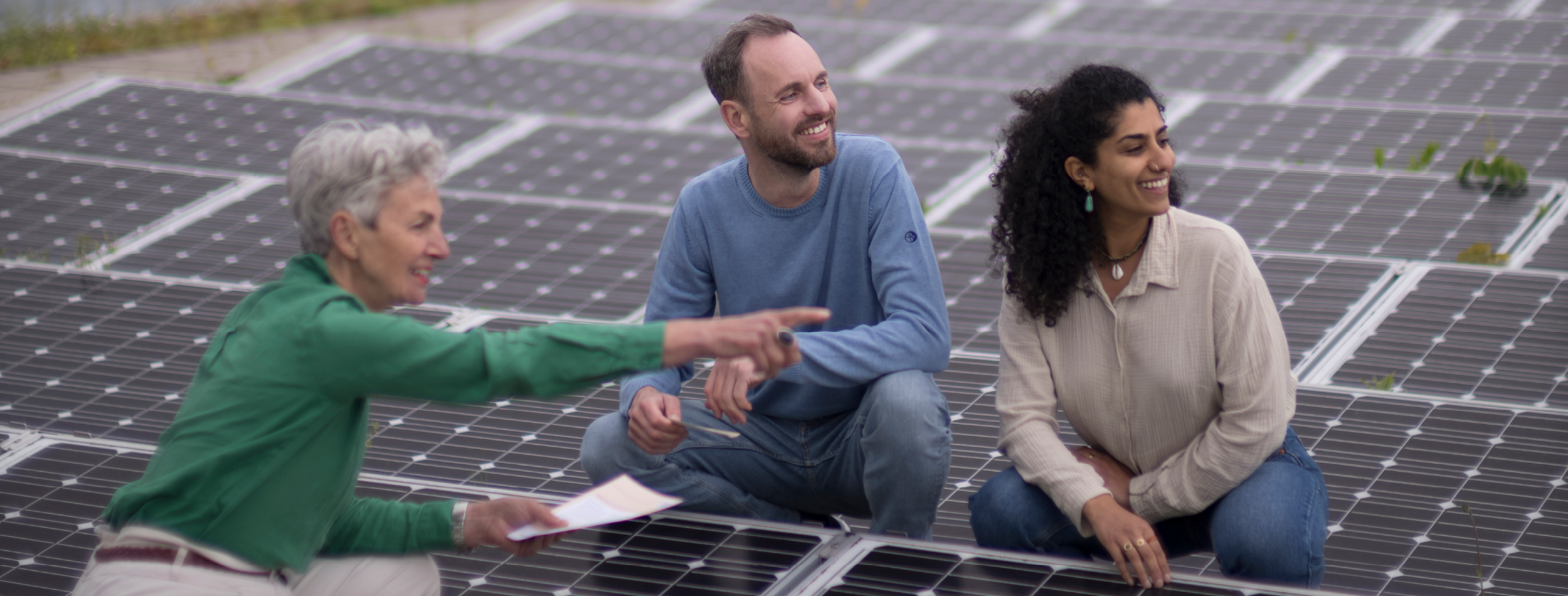 3 Personen, die sich eine Photovoltaik-Anlage ansehen