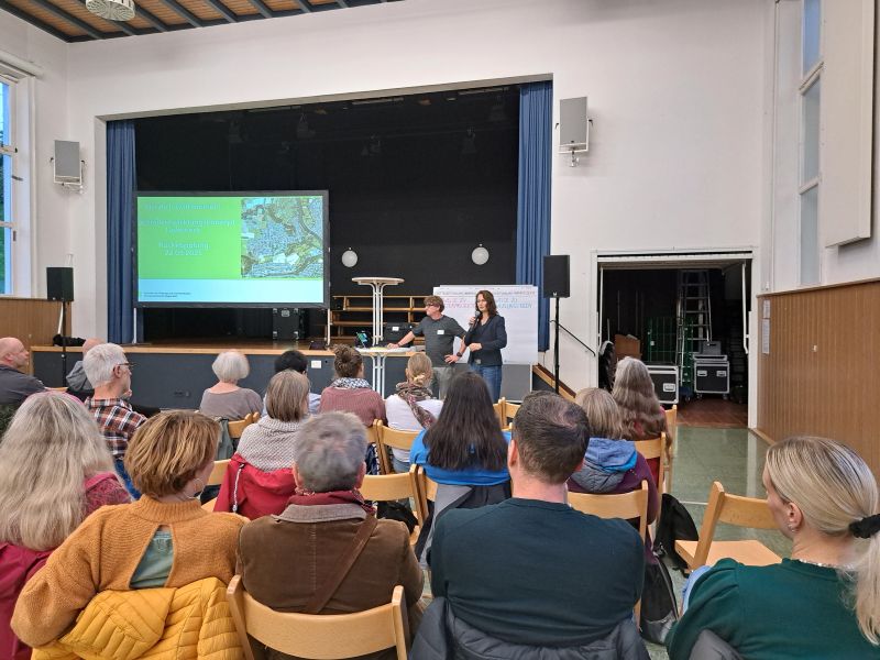 Personen im Publikum hören Vortrag zu