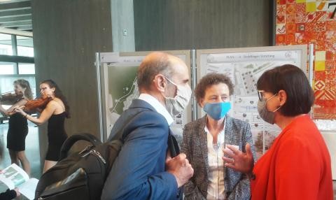 drei Personen unterhalten sich in der Ausstellung