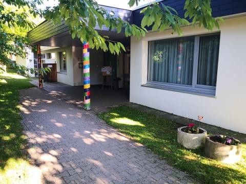 Kita Eingang mit Überdachung auf zwei bunten Pfosten