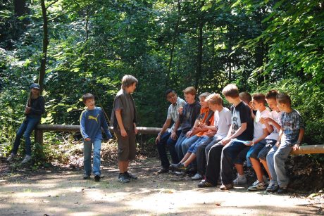 Gruppe Jugendlicher auf einer Bank im Wald