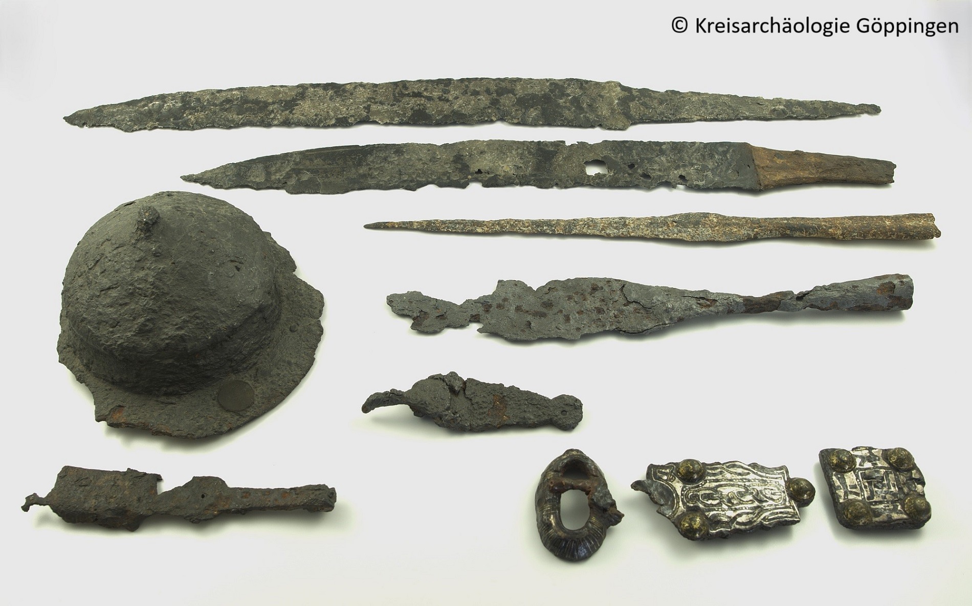 Grabbeigaben aus Donzdorf: Lang- und Kurzschwerter, Lanzenspitzen, Schildbuckel mit Schildfessel, Gürtelhaken, silbertauschierte Gürtelschließe und -beschlag (Foto: Kreisarchäologie Göppingen) Grabbeigaben aus Donzdorf: Lang- und Kurzschwerter, Lanzenspitzen, Schildbuckel mit Schildfessel, Gürtelhaken, silbertauschierte Gürtelschließe und -beschlag (Foto: Kreisarchäologie Göppingen)