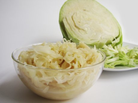 Sauerkraut in einer Galssch&uuml;ssel, daneben ein Wei&szlig;kraukopf