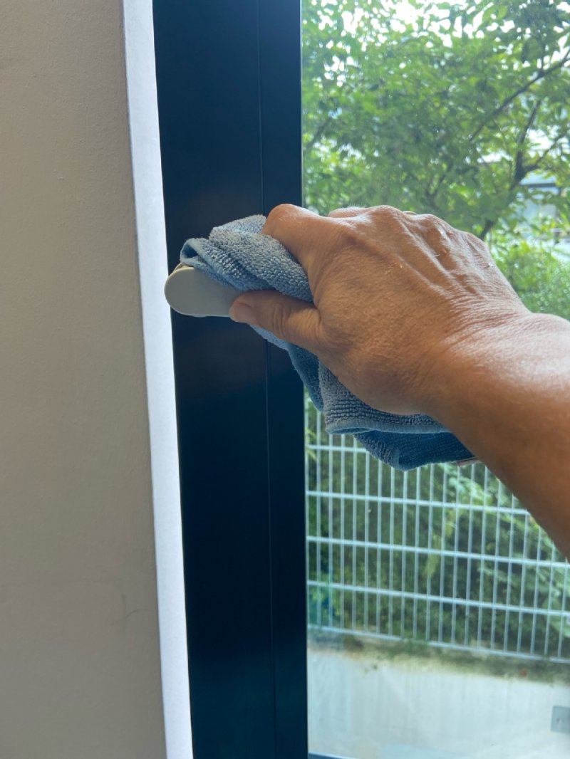 Fenstergriff wird mit blauem Tuch abgewischt 
