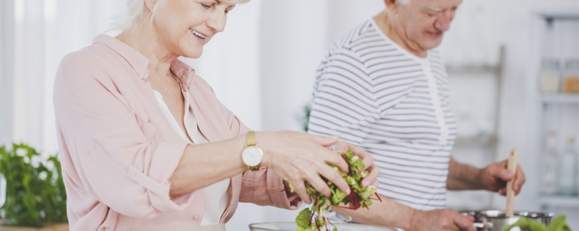 Senioren bereiten gr&uuml;nen Salat zu 
