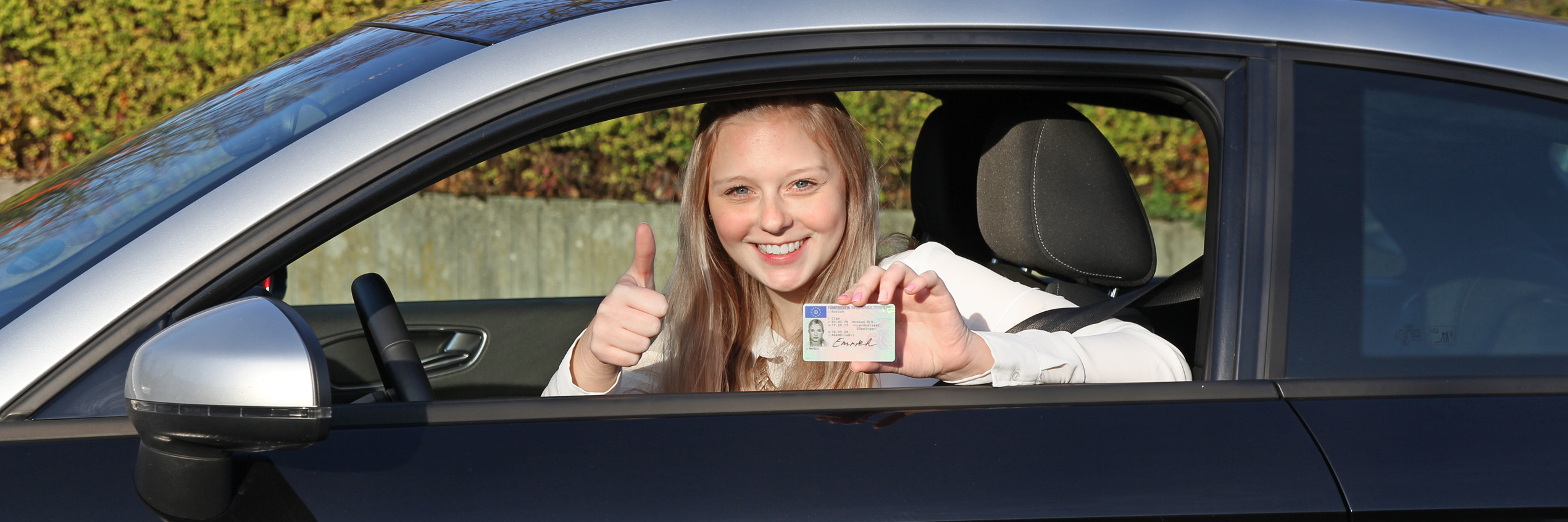 Junge Frau zeigt ihrem Kartenf&uuml;hrerschein