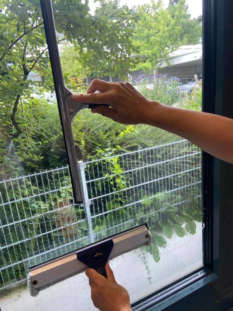 Fenster wird mit einem Abzieher getrocknet